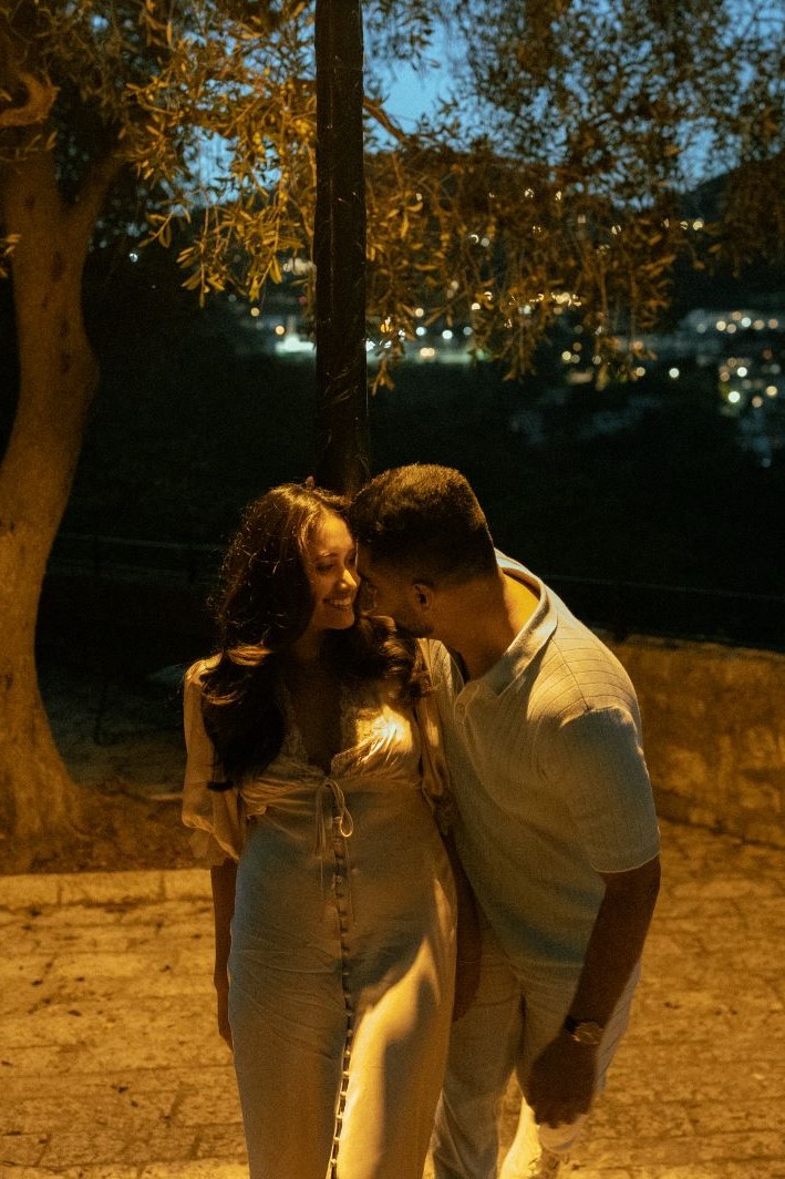 Couple souriant se regardant, éclairé par une lumière orange