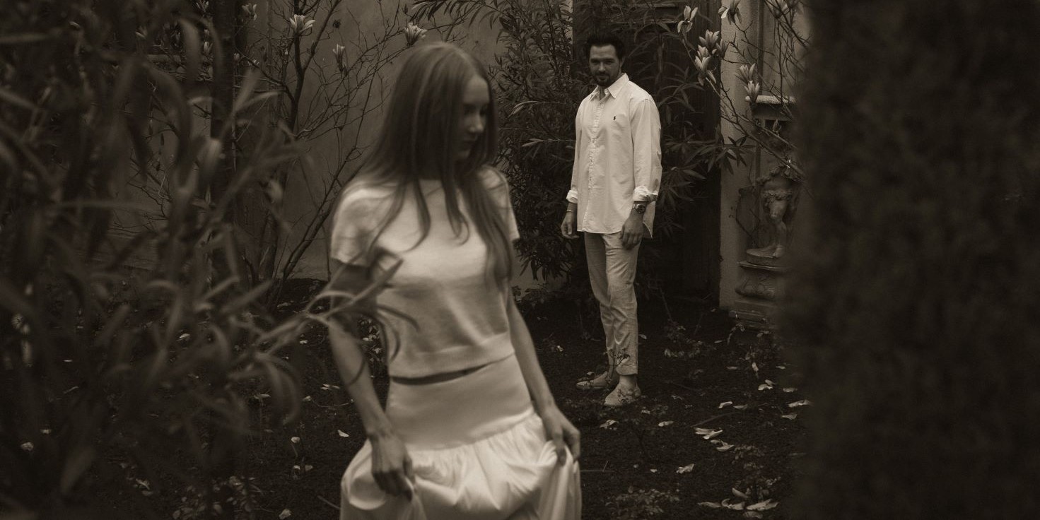 Couple avec l'homme observant la femme qui avance en souriant et en tenant sa jupe