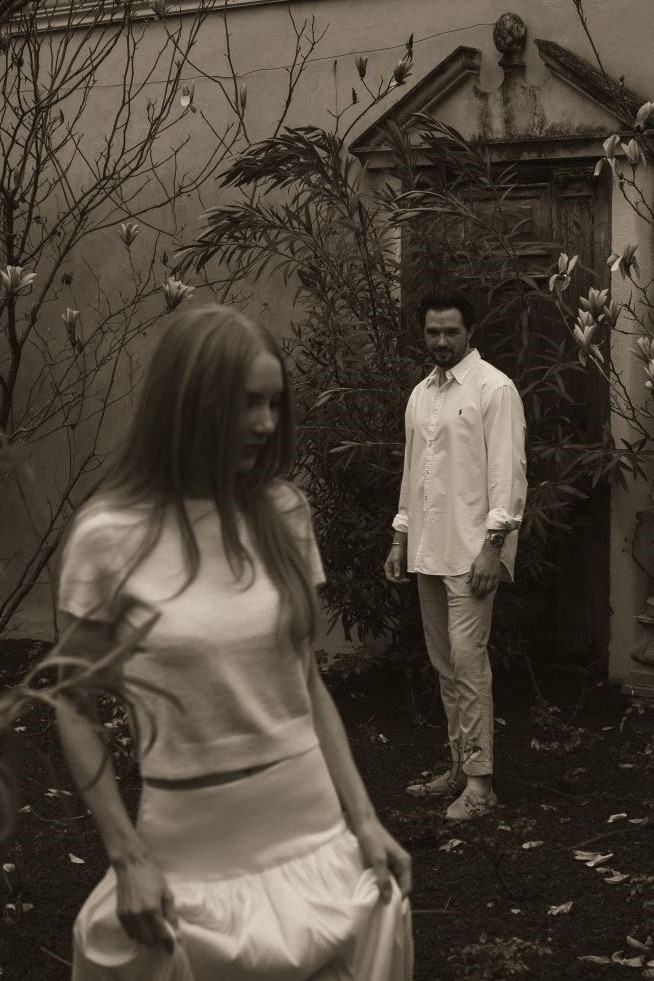 Couple avec l'homme observant la femme qui avance en souriant et en tenant sa jupe