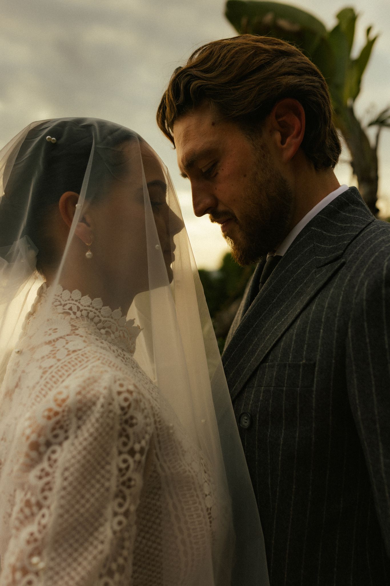 Couple marié se regardant dans les yeux, la femme porte un voile